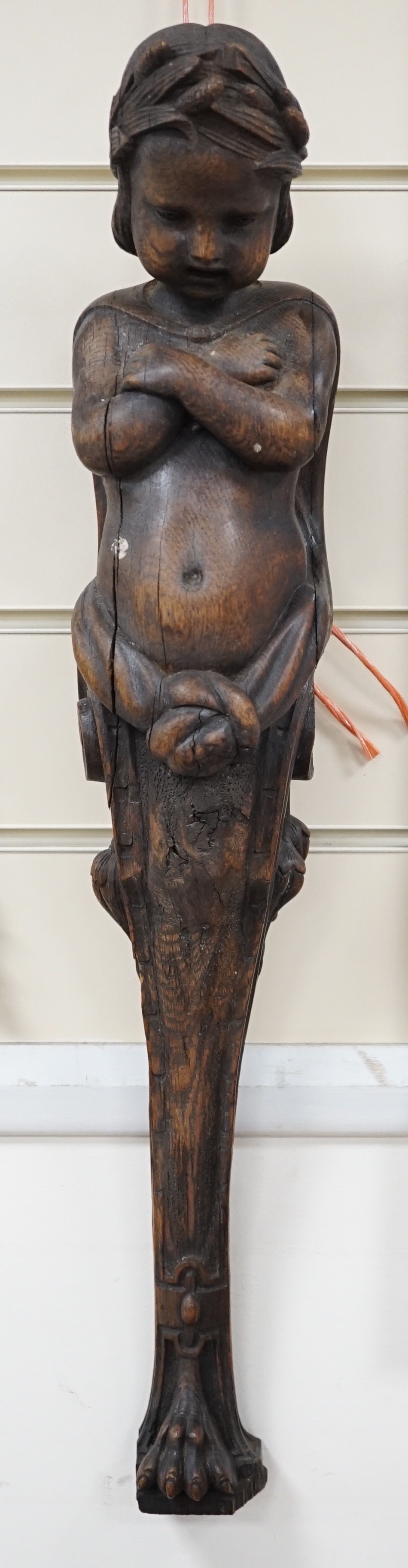 A carved figural wall mount. 64cm tall